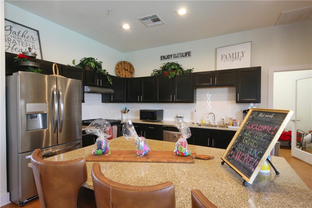 2400 Louis Henna Boulevard, Unit 103 Round Rock, TX 78664 - Photo 20 of 22 a kitchen with stainless steel appliances granite countertop a refrigerator and a stove top oven