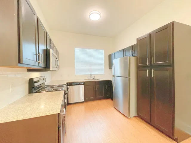 a kitchen with stainless steel appliances granite countertop a refrigerator and a sink
