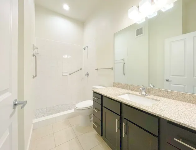 a bathroom with a granite countertop sink toilet and shower
