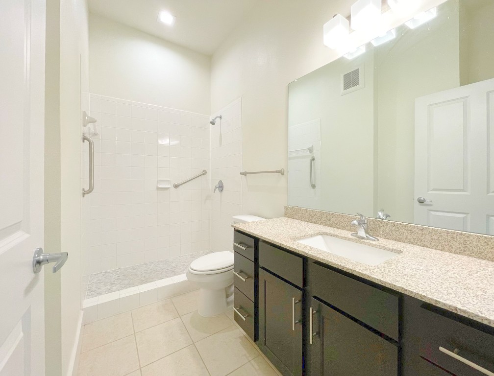 2400 Louis Henna Boulevard, Unit 103 Round Rock, TX 78664 - Photo 9 of 22 a bathroom with a granite countertop sink toilet and shower