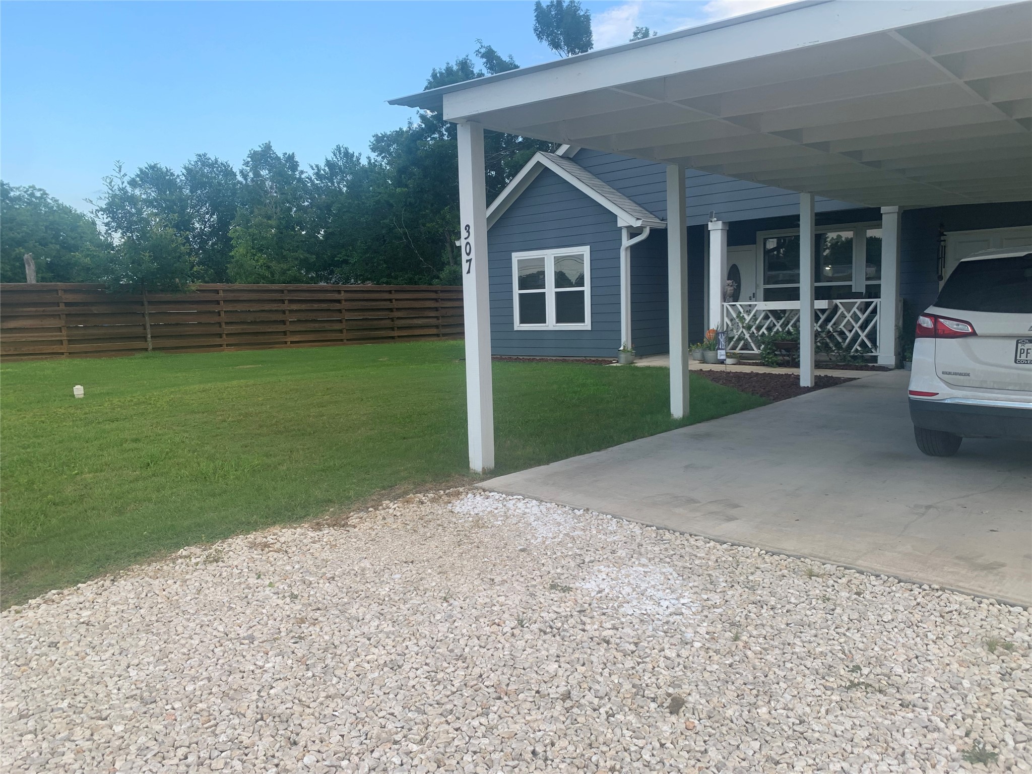307 West Front Street Thorndale, TX 76577 - Photo 6 of 27 View of parking / parking lot with an attached carport and driveway