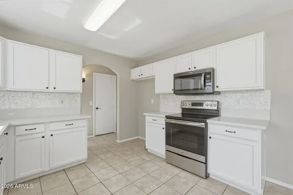 a kitchen with white cabinets stainless steel appliances and a sink