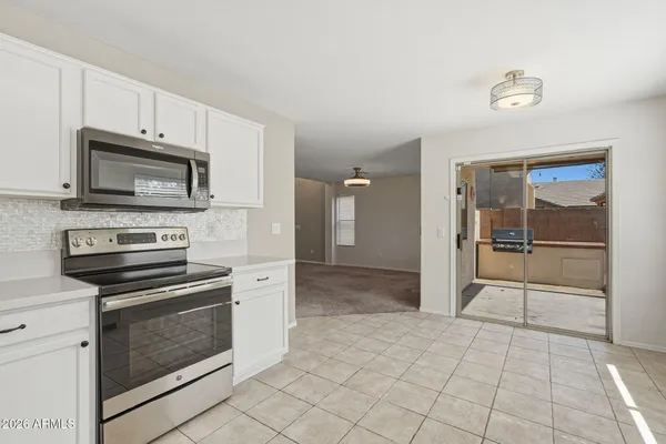a kitchen with granite countertop a stove microwave and a refrigerator