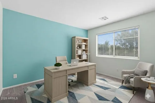 a view of a workspace with furniture and a window