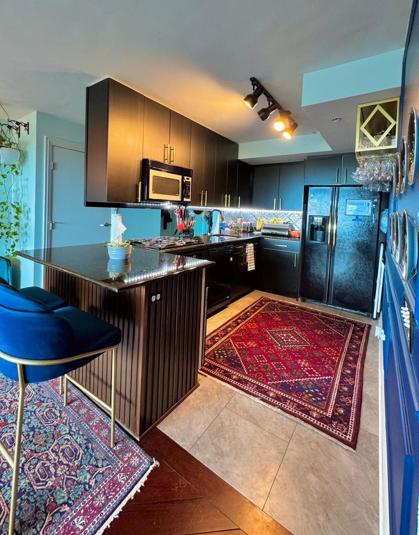 1720 Maple Avenue, Unit 2680 Evanston, IL 60201 - Photo 21 of 74 a kitchen with stainless steel appliances kitchen island granite countertop a stove a sink dishwasher and cabinets