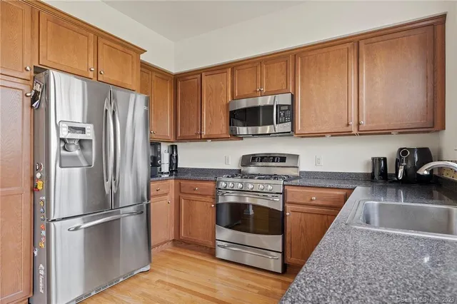 a kitchen with stainless steel appliances granite countertop a refrigerator stove a sink and microwave