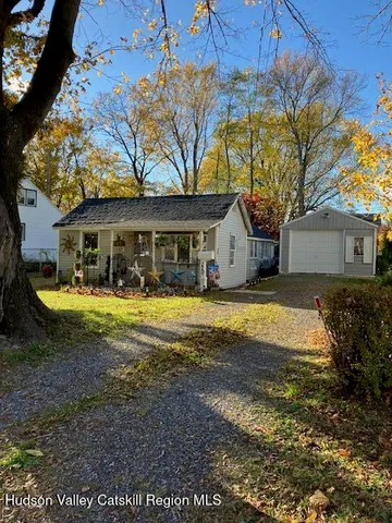 a view of house with swimming pool and a yard