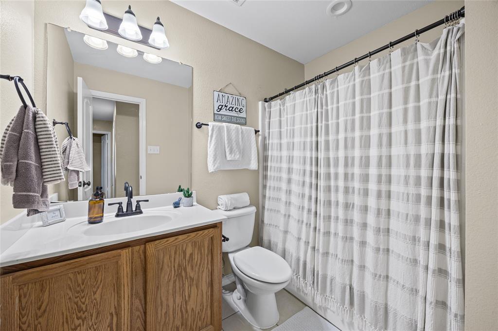112 Springfield Lane Red Oak, TX 75165 - Photo 25 of 40 a bathroom with a sink a toilet and shower curtain