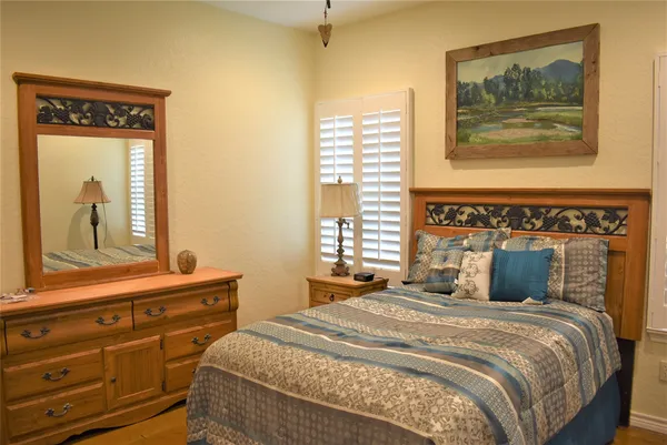 a bedroom with a bed and a mirror on the dresser