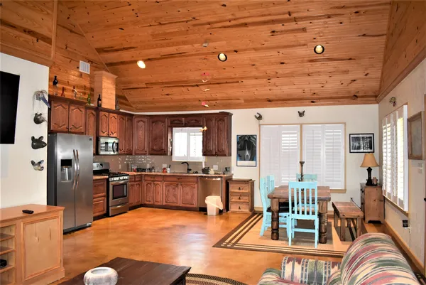 a living room with stainless steel appliances kitchen island granite countertop furniture and a kitchen view