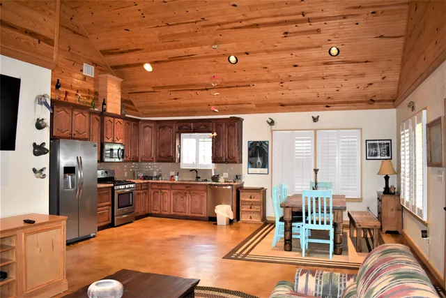 a living room with stainless steel appliances kitchen island granite countertop furniture and a kitchen view