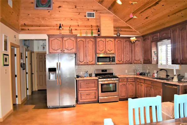 a kitchen with stainless steel appliances granite countertop a sink a stove and a refrigerator