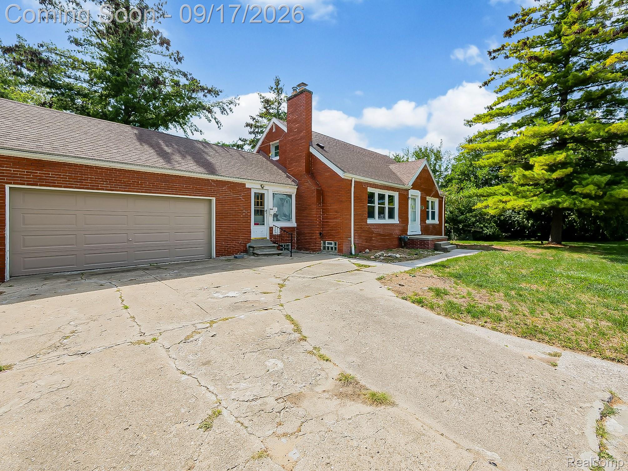 14102 Toepfer Road Warren, MI 48089 - Photo 31 of 39 Brick exterior with a peaked roofline, attached garage with a taupe door, and a concrete driveway