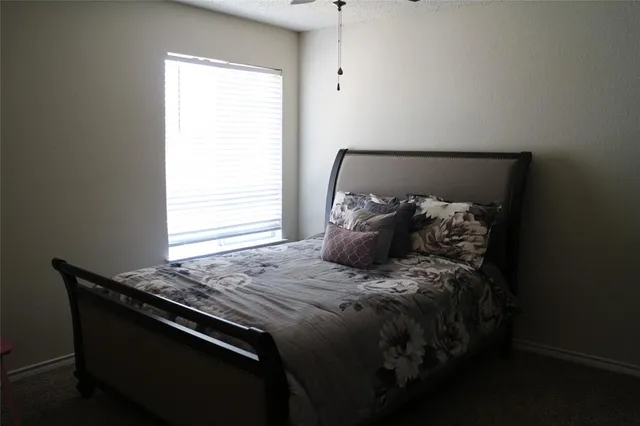 a bed sitting in a bedroom next to a window