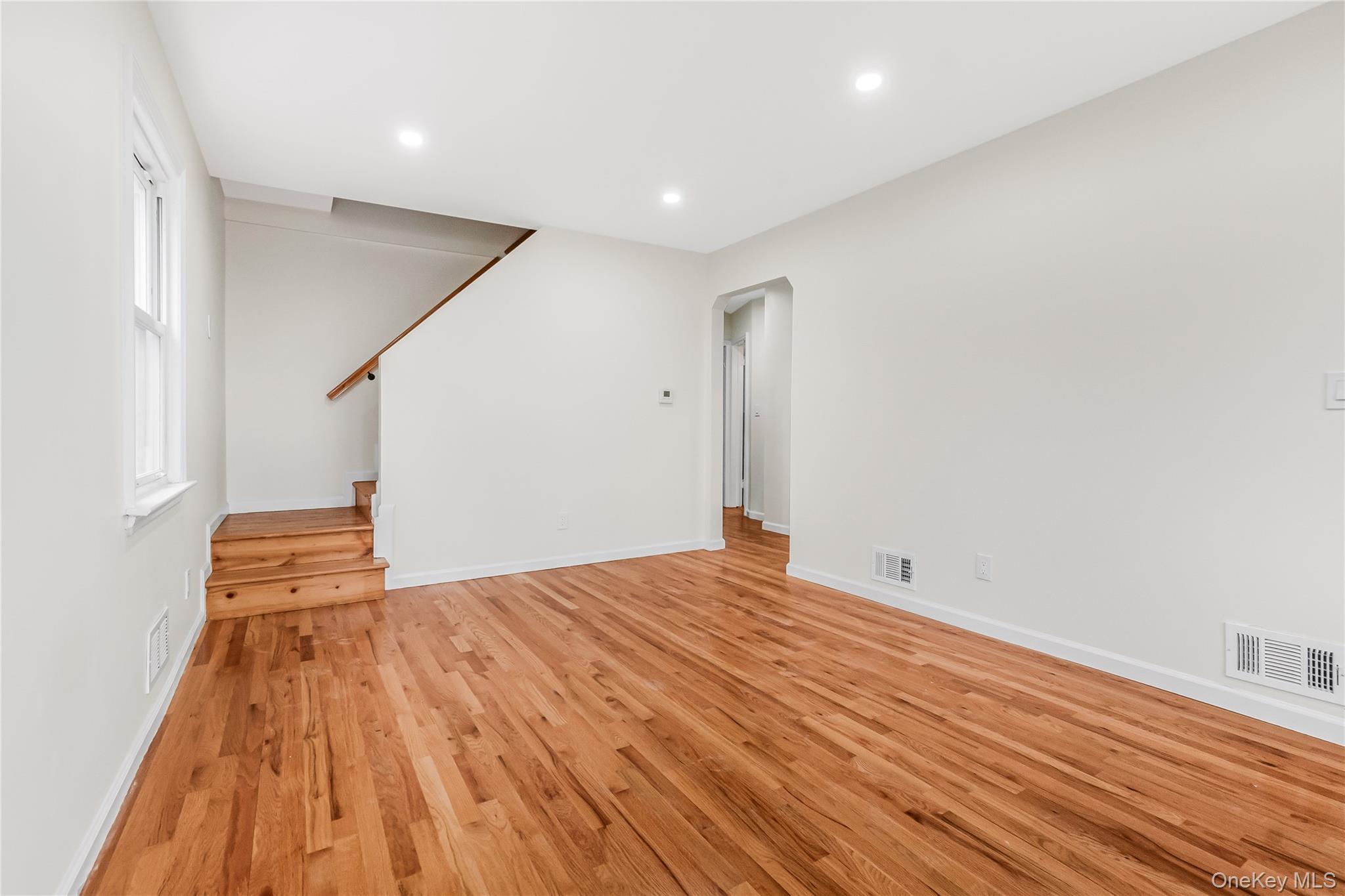 243-25 132nd Road Queens, NY 11422 - Photo 11 of 41 a view of an empty room with wooden floor