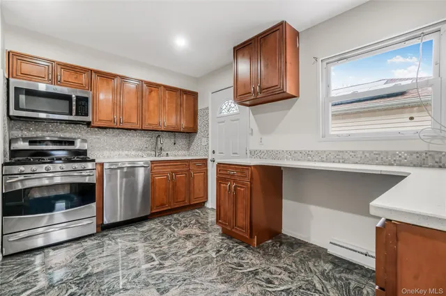 a kitchen with stainless steel appliances granite countertop a stove a sink and a microwave