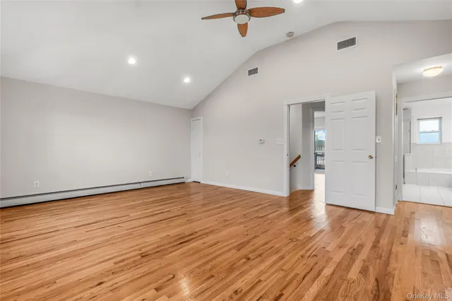 an empty room with wooden floor and window