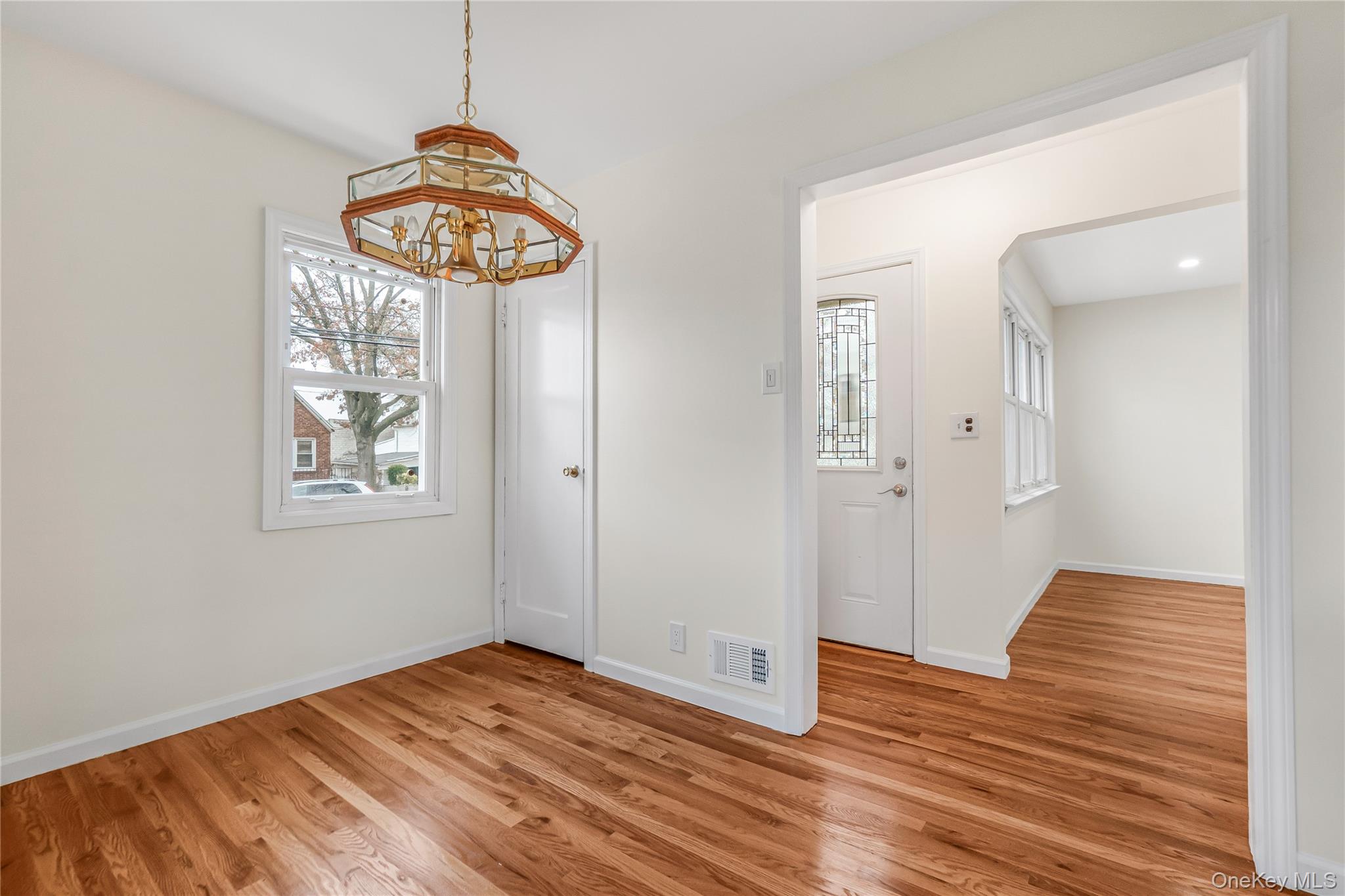 243-25 132nd Road Queens, NY 11422 - Photo 8 of 41 a view of an empty room with wooden floor and a window