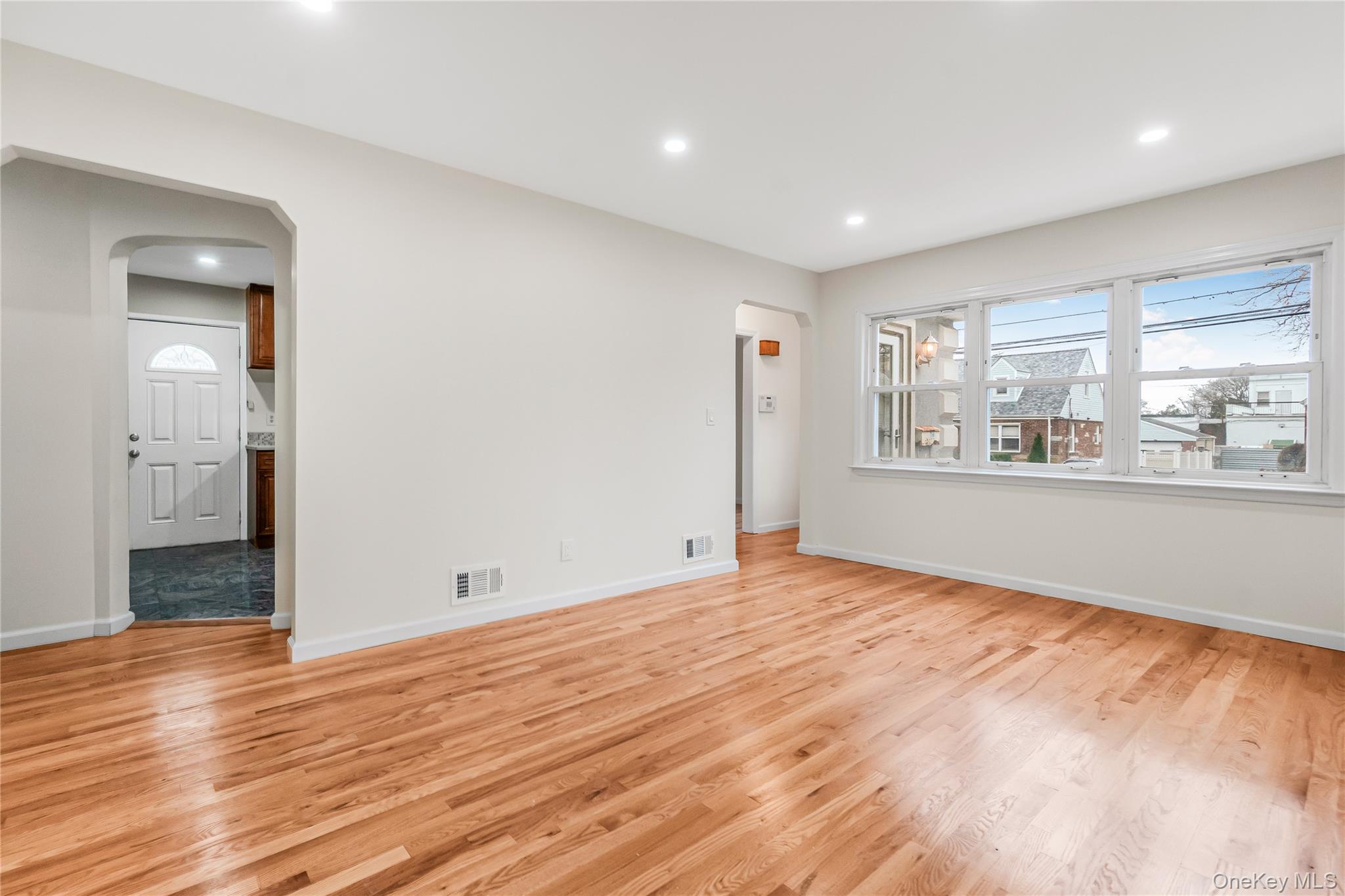 243-25 132nd Road Queens, NY 11422 - Photo 10 of 41 a view of an empty room with wooden floor and a window