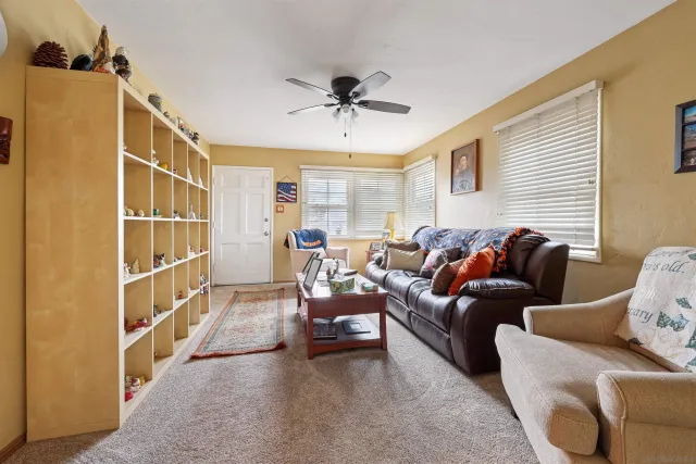 a living room with furniture and a ceiling fan
