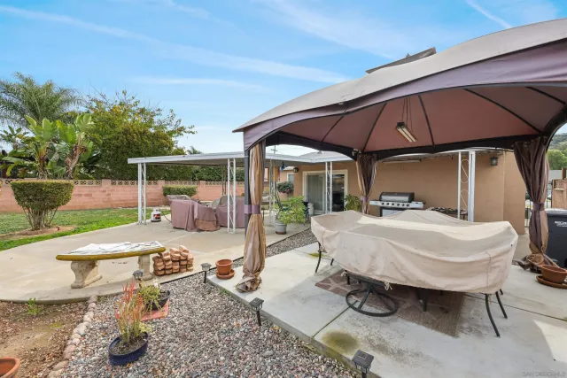 a view of a patio with table and chairs under an umbrella