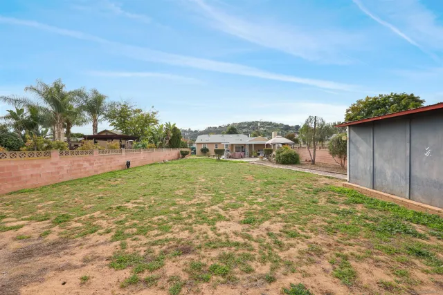 a view of a house with a yard and sitting area