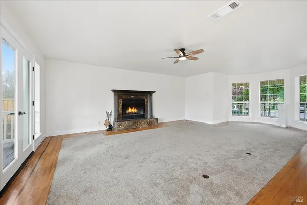 an empty room with a fireplace and fan