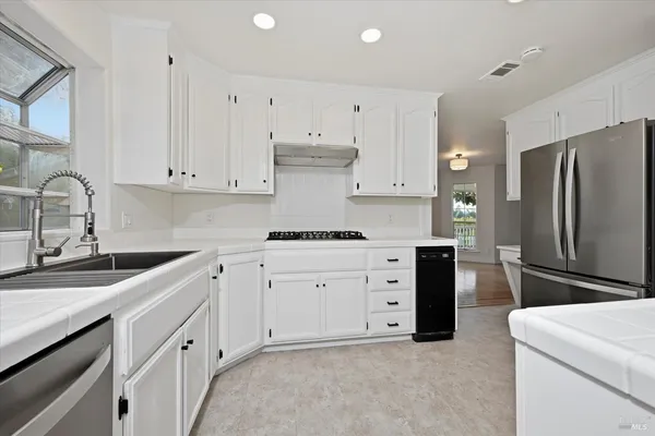 a kitchen with cabinets appliances a sink and a counter top
