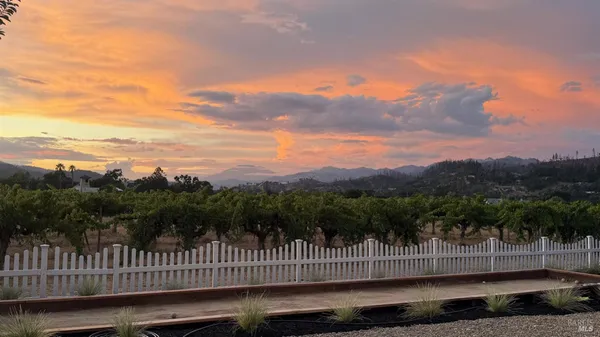 a view of a green field with wooden fence