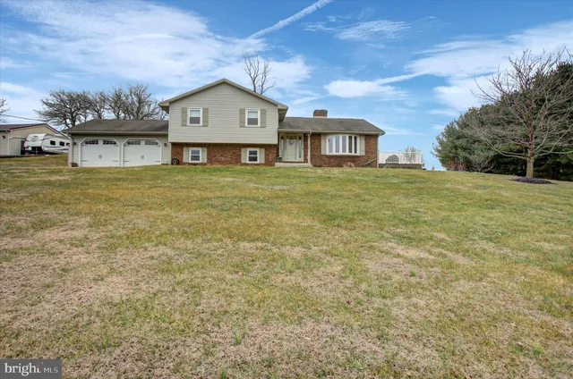 a view of a big house with a big yard and large trees