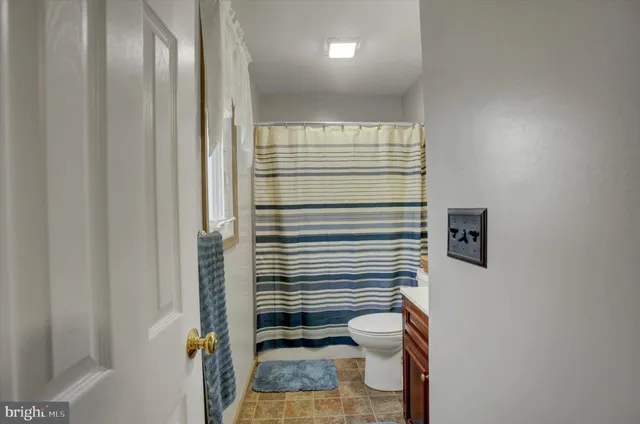 a bathroom with a toilet and a shower curtain