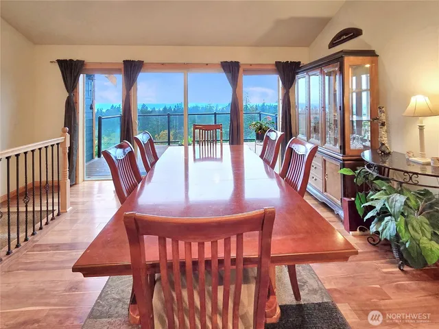a view of a dining room with furniture large windows and wooden floor