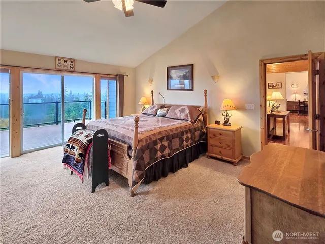 a bedroom with a bed and large windows