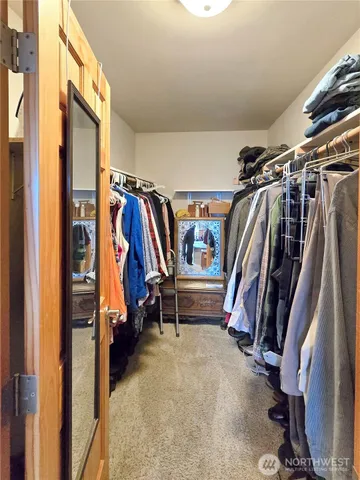 a view of walk in closet with clothes and shoes