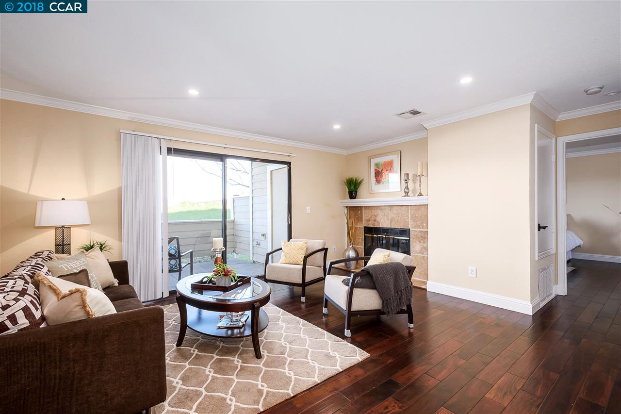 a living room with fireplace furniture and a large window