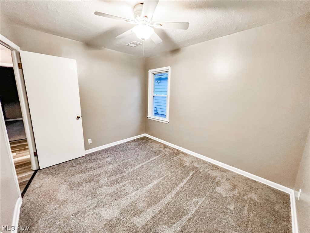 6830 Oakwood Road Parma Heights, OH 44130 - Photo 5 of 22 Carpeted empty room with ceiling fan and a textured ceiling