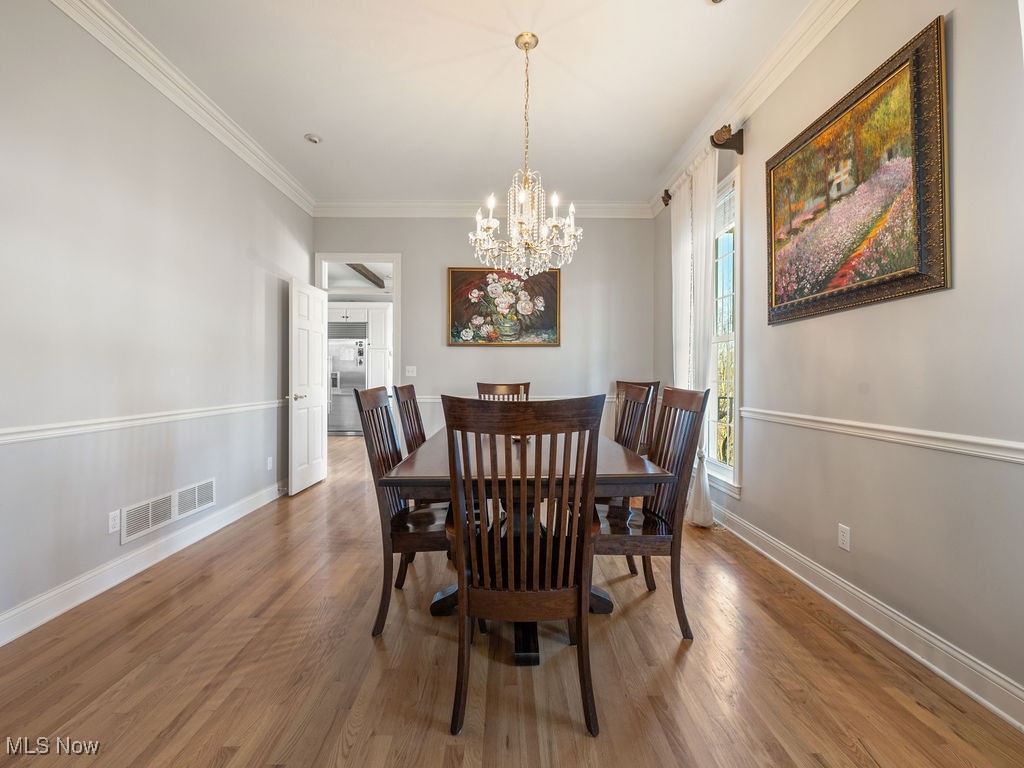 469 Vincent Hill Road Cairo, WV 26337 - Photo 14 of 48 Dining room featuring visible vents, a chandelier, baseboards, ornamental molding, and wood finished floors