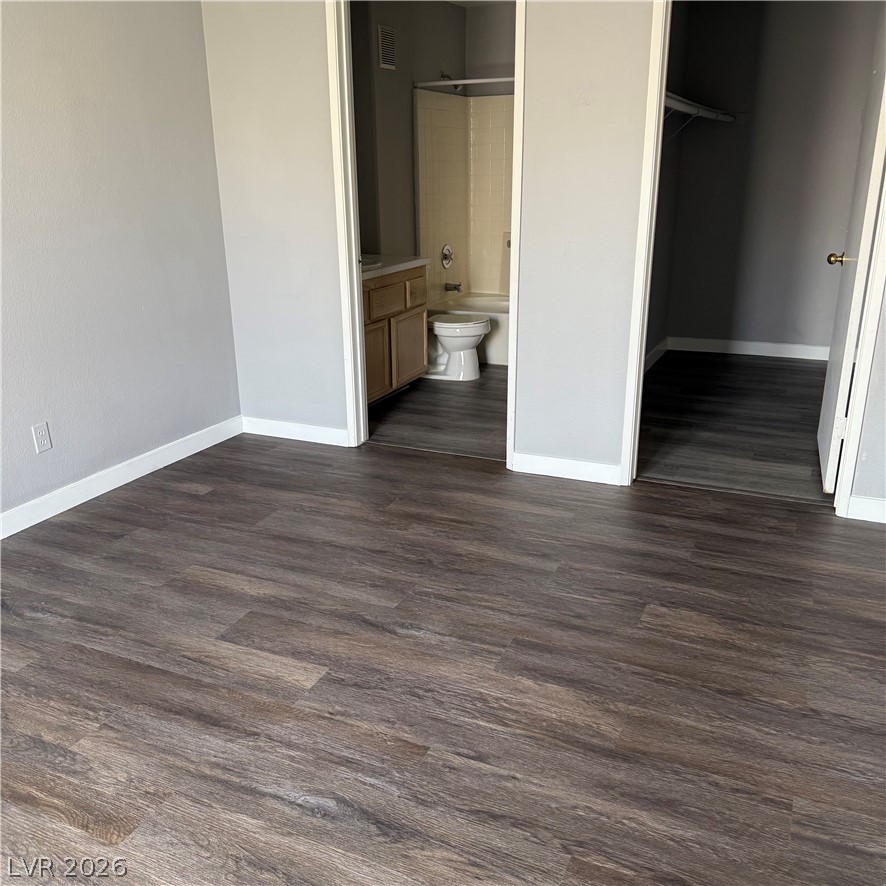 1830 North Pecos Road, Unit 258 Las Vegas, NV 89115 - Photo 14 of 14 Rich wood-look flooring extends throughout this versatile space, connecting to a private bathroom and closet.