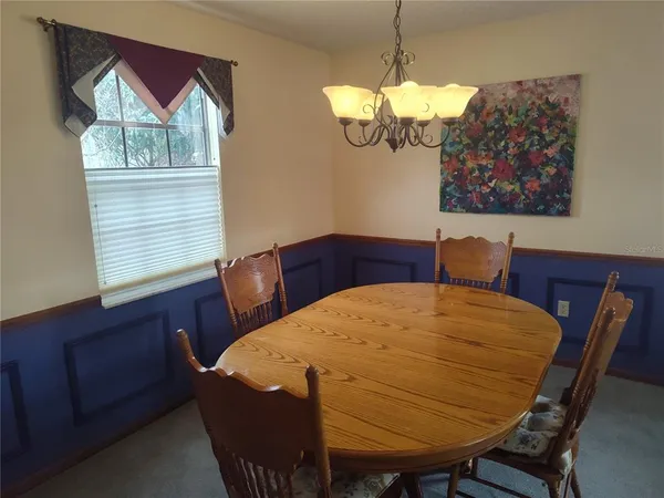 a view of a dining room with furniture and a chandelier