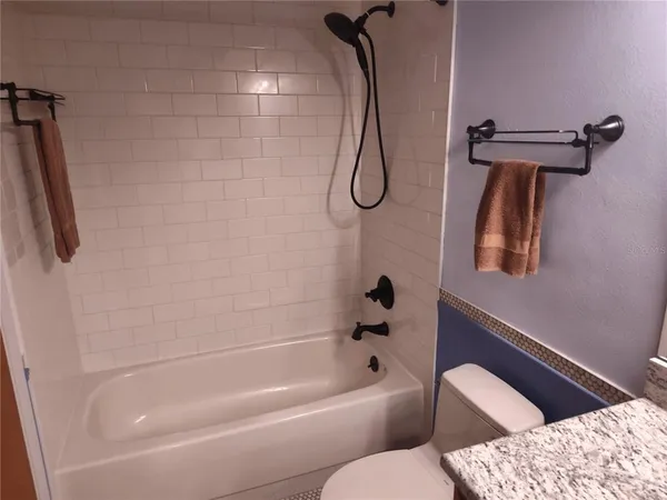 a bathroom with a bath tub a toilet and a shower