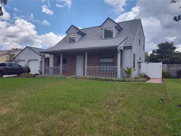 a view of a house with a big yard and large tree