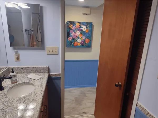 a bathroom with a granite countertop sink vanity and a mirror