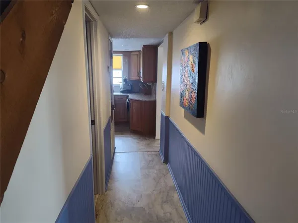 a view of a hallway with wooden floor and staircase