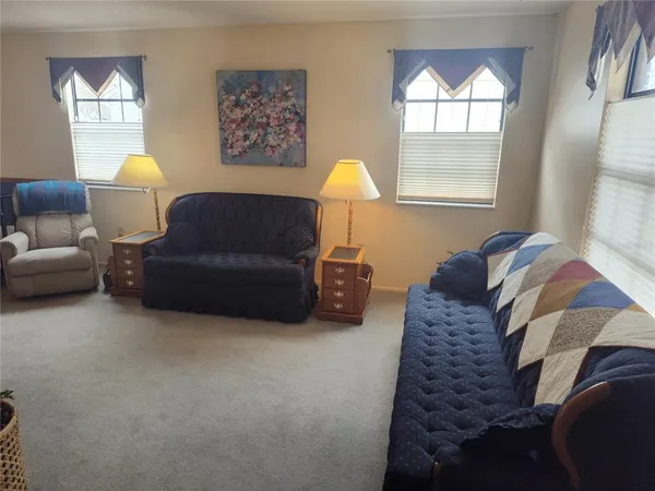 a living room with furniture a lamp and a window