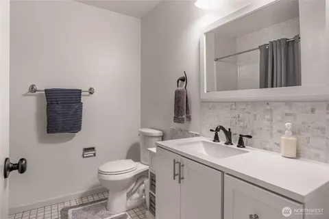 a bathroom with a toilet a sink and mirror