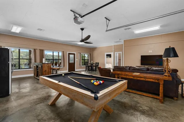 a living room with furniture flat screen tv and floor to ceiling window