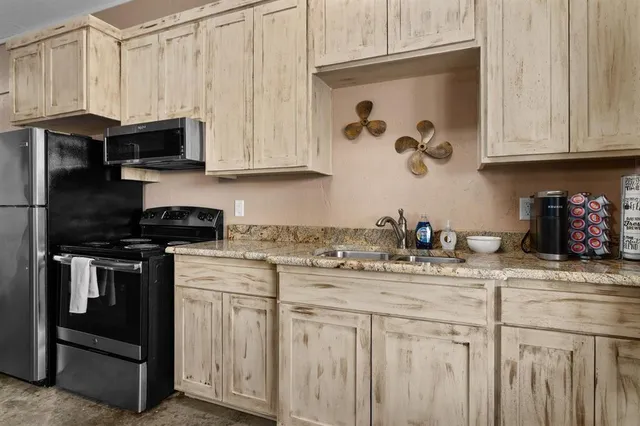 a kitchen with stainless steel appliances granite countertop a sink a stove and a microwave