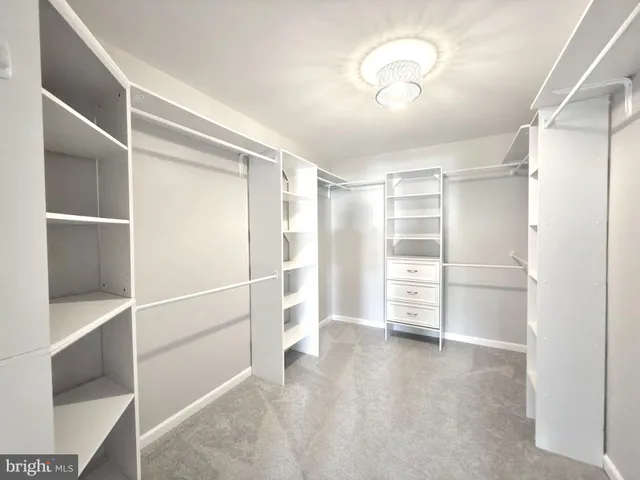 an empty room with a fan & windows