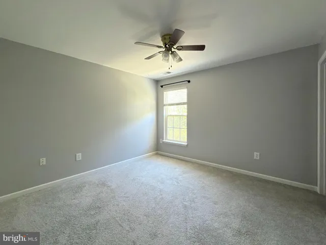 a view of a hallway with a ceiling fan