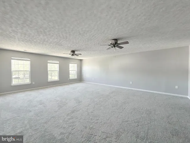 a view of a livingroom with a ceiling fan and window